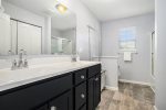 Primary bathroom has a shower tub combo and a large vanity area 
